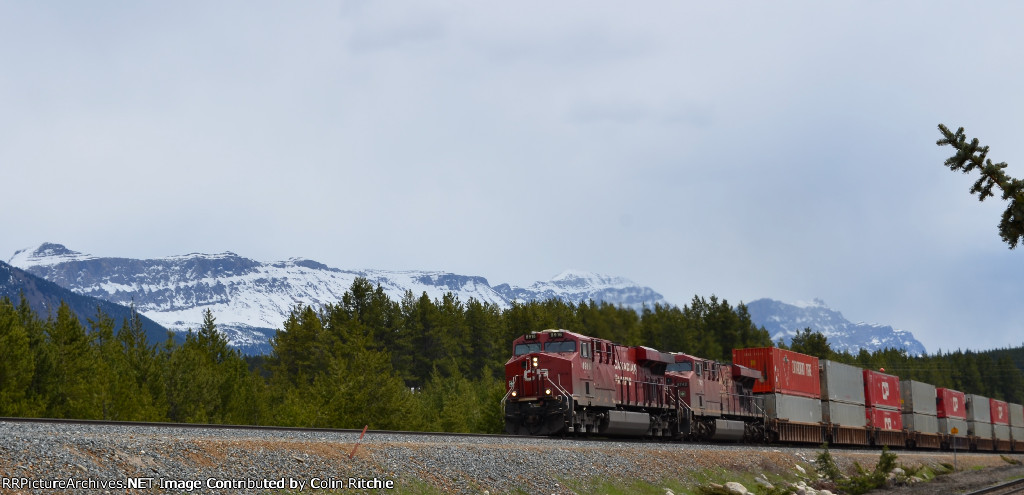 CP 8916/8742 W/B through Banff, the Rocky Mountains in the background.